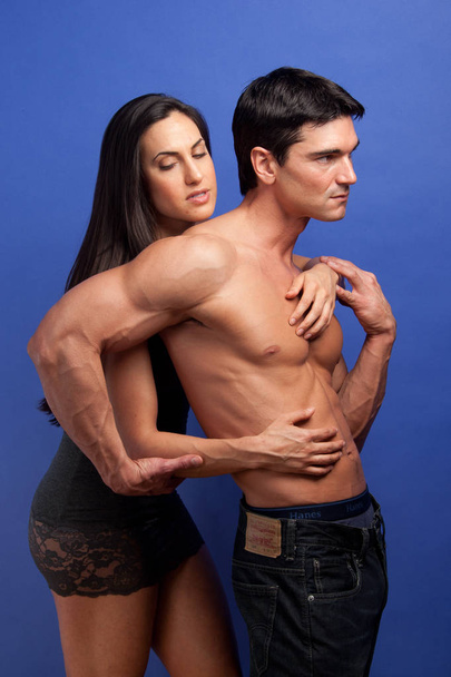The sexy couple pose together in an embrace. - Photo, Image
