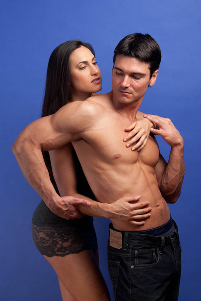 The sexy couple pose together in an embrace. - 写真・画像