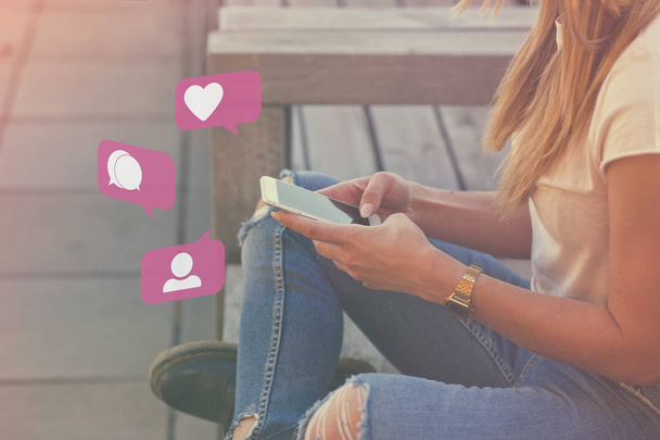 Jong volwassen meisje beïnvloeder gebruik van sociale Media op Smartphone op buiten, als, volgeling, commentaar Bubble pictogrammen - Foto, afbeelding