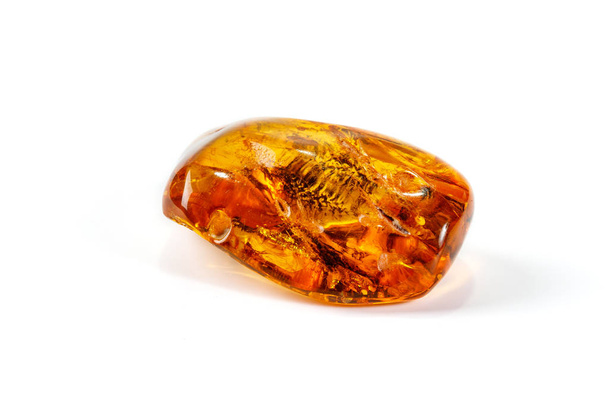 Macro close-up van Amber minerale steen met spin op witte achtergrond - Foto, afbeelding