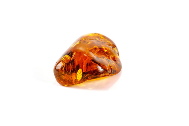 Macro close-up van Amber minerale steen met spin op witte achtergrond - Foto, afbeelding