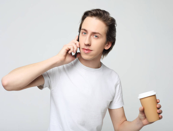  Portrait of happy man talking on phone and drinking coffee - Фото, изображение
