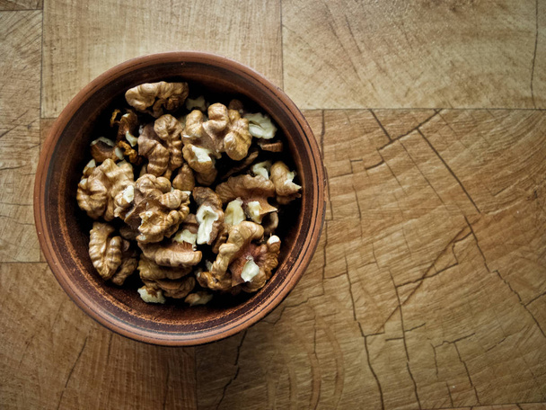 Peeled walnuts in a plate of clay. - Fotografie, Obrázek