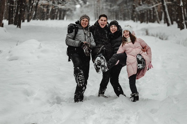 Happy friends in winterwear playing with snow in park. Ukraine 2019 - Zdjęcie, obraz