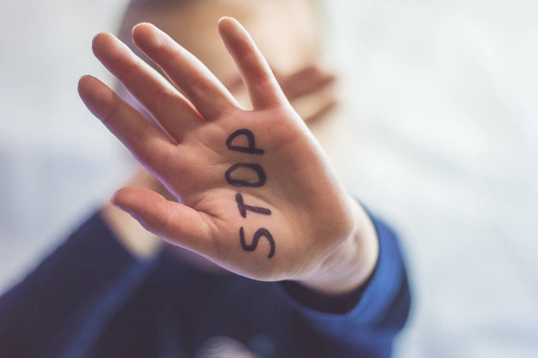La niña asustada muestra la palabra "Stop" escrita en el brazo. Los niños son objeto de violencia y publicación en el hogar y la escuela concepto y los derechos de los niños
. - Foto, imagen