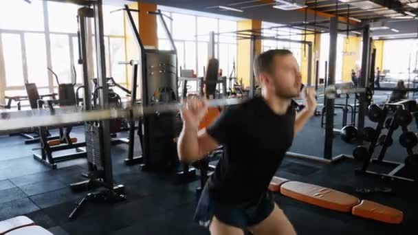 Sportsman warm up before training. Man squat with barbell in gym - Кадри, відео
