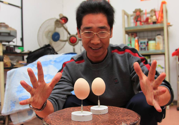 -Cui Juguo, who set a Guinness World Record for balancing an ostrich egg on a pin, shows the two eggs he balanced on needle points at his home in Changsha city, central Chinas Hunan province, 8 November 2011 - Photo, Image