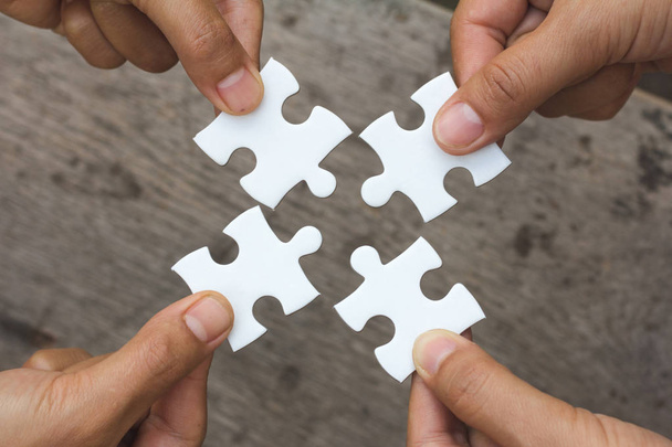 Gens d'affaires Holding Jigsaw Puzzle, groupe de gens d'affaires utilisant un puzzle pour démontrer la nécessité de travailler dans la même direction pour travailler pleinement et efficacement - Photo, image