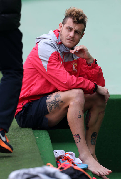 Alessandro Diamanti of Chinas Guangzhou Evergrande rests as tattoos including a cute image of Japanese fictional character Hello Kitty on his legs during a training session for a football match of the AFC Champions League 2014 against Jeonbuk Hyundai - Foto, imagen