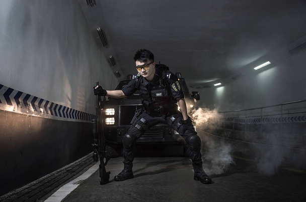 Ein Swat-Polizist posiert mit einer Waffe für Rekrutierungsplakate, um neue Rekruten in der Stadt Chengdu in der südwestchinesischen Provinz Sichuan anzulocken, 1. Juli 2014 - Foto, Bild