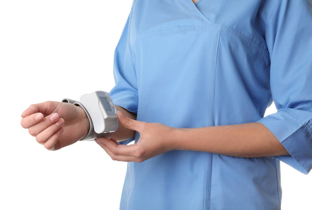 Naislääkäri, joka käyttää verenpainemittaria valkoisella taustalla, lähikuva. Lääketieteellinen esine
 - Valokuva, kuva