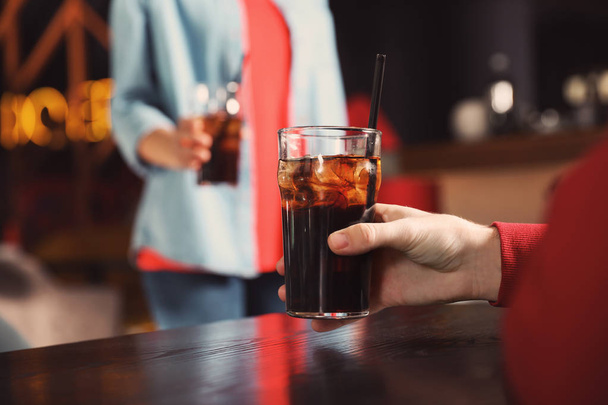 Man holding glass of cola at table in bar, closeup. Space for text - Photo, Image