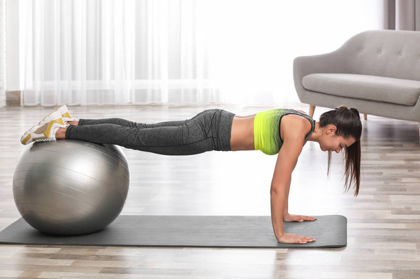 Young woman doing exercise with fitness ball at home - Photo, image