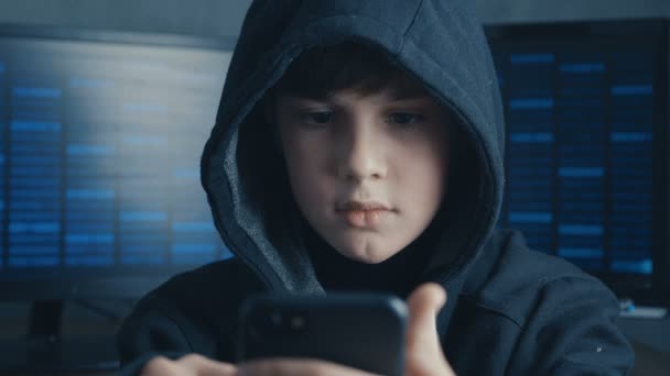Jonge hooded hacker kind met behulp van een smartphoneapparaat om te kapen. Genie boy wonder hacks systeem in cyberspace. - Video