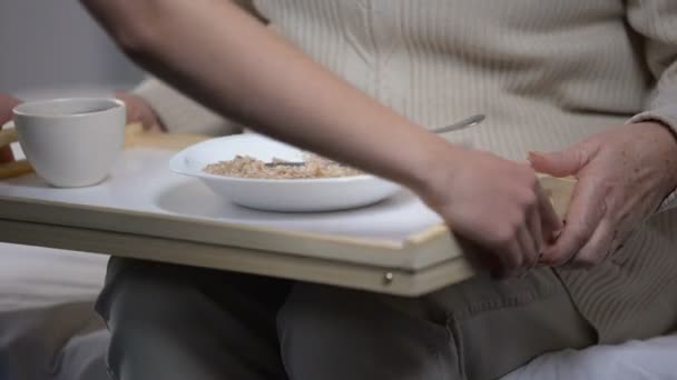 Nurse serving dinner to old patient, elderly woman refusing to eat porridge - Video, Çekim