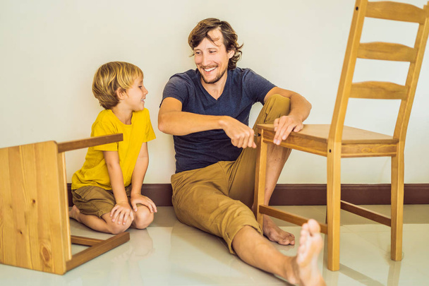 Father and son assembling furniture. Boy helping his dad at home. Happy Family concept - Fotografie, Obrázek