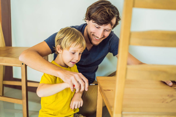 Father and son assembling furniture. Boy helping his dad at home. Happy Family concept - Fotó, kép