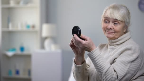Elegant old woman applying skin powder and refusing medical pills, nursing home - Záběry, video