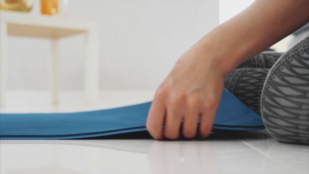 Close up of a young beautiful woman dressed in blue jogging or a fitness mat after working at home in the living room. - Footage, Video