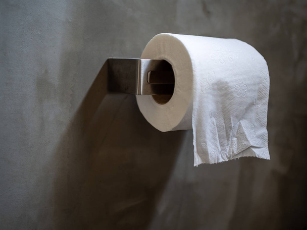 Witte schone wc-papier rollen in toilet op betonnen muur achtergrond met kopie ruimte. - Foto, afbeelding