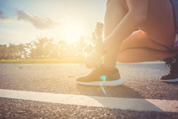 Vrouw slijtage sport schoen op tekstgroep in lopende Hof achtergrond. Gezondheid oefening levensstijl concept. - Foto, afbeelding