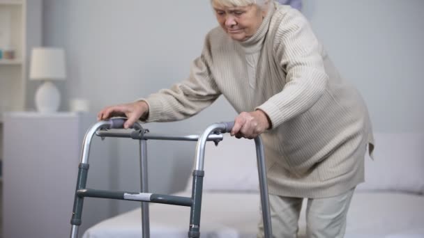 Elderly woman with walking frame, medical equipment using after trauma, hospital - Кадры, видео