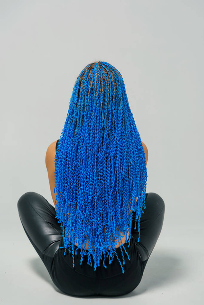 Long Zi-Zi pigtails in blue. Braid weaving technique. Hairdressing services. Afrokosichki Weave African braids. Hairstyle. Girl sitting on a white background. - Photo, Image