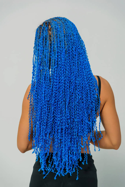 Long Zi-Zi pigtails in blue. Braid weaving technique. Hairdressing services. Afrokosichki Weave African braids. Hairstyle. Girl standing on a white background. - Photo, Image