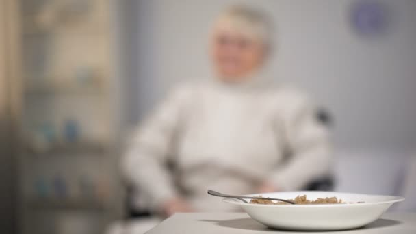 Sad old woman in wheelchair looking at untasty dinner in medical center, sorrow - Filmmaterial, Video