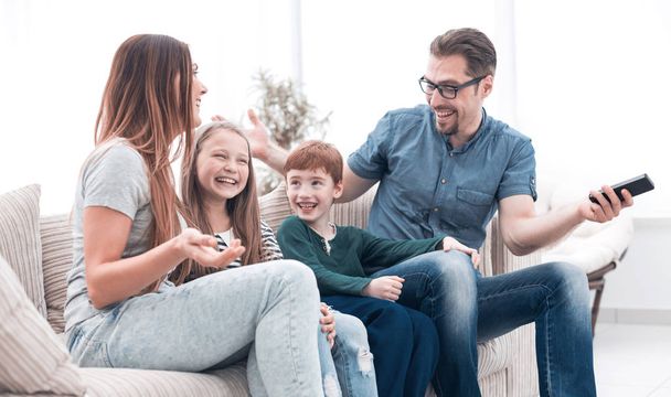 cheerful family sitting on the couch in the living room - Foto, Imagen