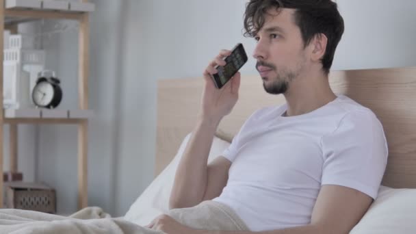 Man Talking on Phone while Lying on Side in Bed - Materiał filmowy, wideo