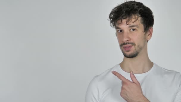 Young Casual Man Pointing on Side, White Background - Footage, Video