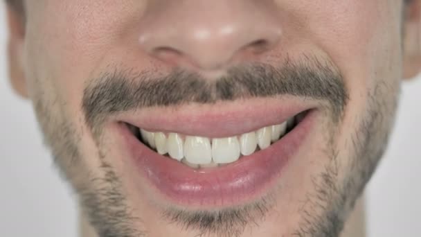 Κοντινό πλάνο της χαμόγελο στα χείλη και τα δόντια του ανθρώπου γενειάδα, λευκό φόντο - Πλάνα, βίντεο