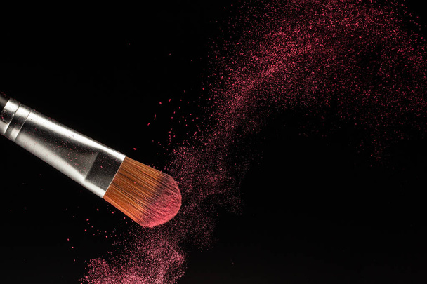 Salpicadura de polvo y pincel para artista de maquillaje o blogger de belleza en fondo negro - Foto, Imagen