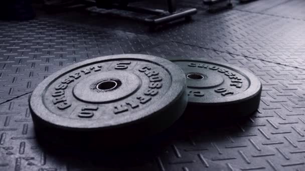 体力トレーニングに使用する準備ができてのジムの床に重い重量プレートのクローズ アップ。フィットネス運動スポーツ コンセプト、ジムの床に機器バーベル重量プレート - 映像、動画