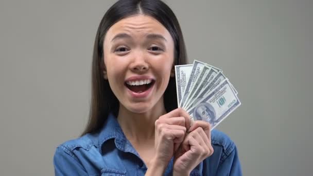 Χαρούμενα Ασιατική γυναίκα δείχνει μάτσο δολάρια για την κάμερα, ο νικητής του κλήρωση, πλούτος - Πλάνα, βίντεο