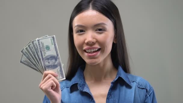 Töprengő ázsiai hölgy nézi euró, csomó gondolkodni vásárlás, közelről - Felvétel, videó
