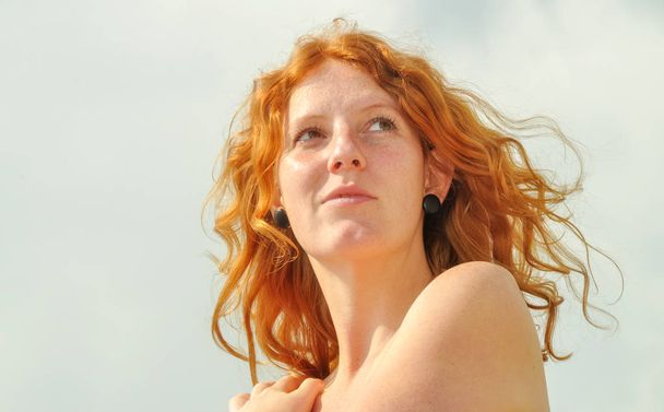 Kaunis aistillinen muotokuva lähikuva huomaavainen nuori punapää kaipuu kihara nainen lomalla meren äärellä kopioi tilaa
 - Valokuva, kuva