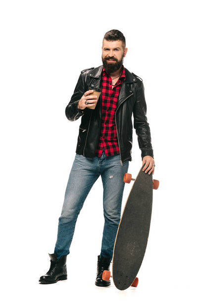 bearded man in black leather jacket posing with longboard and coffee to go isolated on white - Φωτογραφία, εικόνα