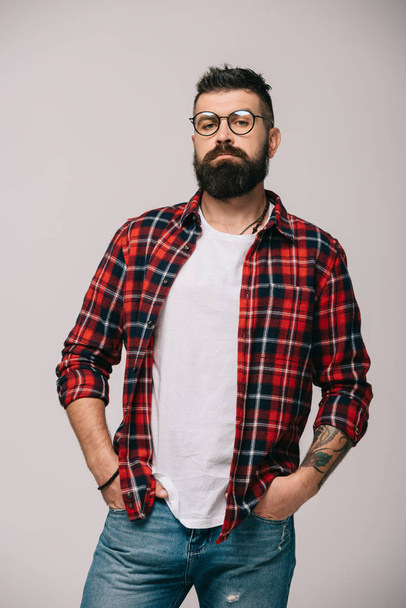 confident bearded man posing in checkered shirt isolated on grey - Photo, image