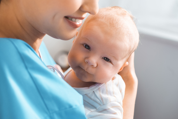 recortado disparo de feliz joven madre llevando adorable bebé en la habitación del hospital
 - Foto, imagen