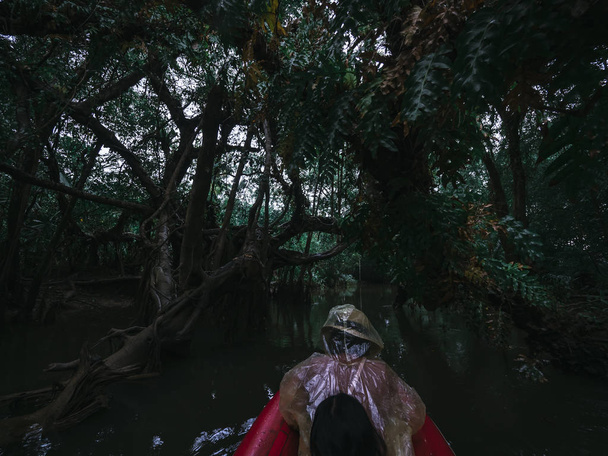Imperméable deux peuples ware jouent au canoë dans la jungle de serpents
 - Photo, image