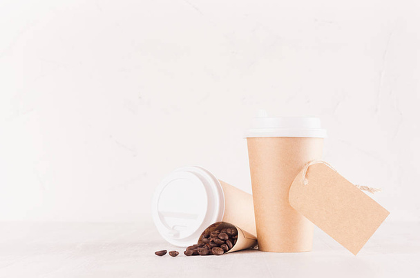 Coffee packing mockup - craft brown paper cups, coffee beans, blank white caps and label on white wood board with copy space, coffee shop interior. Modern elegant concept for branding identity, advertising, design. - Photo, Image