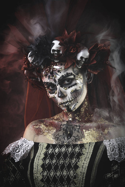 Молодая девушка Санта Муэрте с художественным макияжем на Хэллоуин и скаллами в волосах - Фото, изображение
