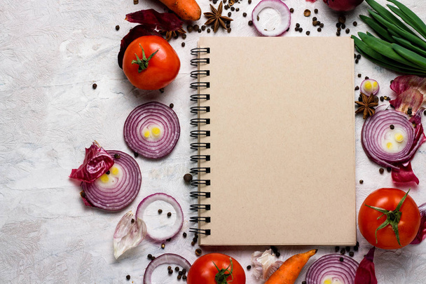Fresh Vegetables around the Notepad for Food Recipes on a light background. The concept of cooking, vegetarianism and healthy eating. - Фото, зображення