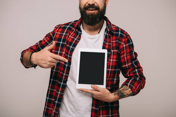 vue recadrée de l'homme pointant vers la tablette numérique avec écran blanc, isolé sur gris
 - Photo, image