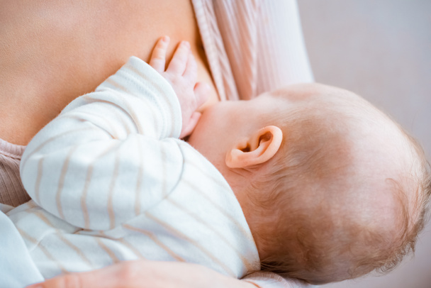 close-up partial view of young mother breastfeeding infant baby - Photo, Image