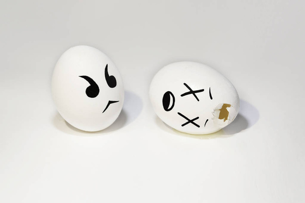 two eggs, a broken egg lies on its side, painted emotions, white background - Фото, изображение