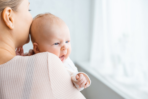 colpo ritagliato di giovane madre baciare adorabile neonato a casa
 - Foto, immagini