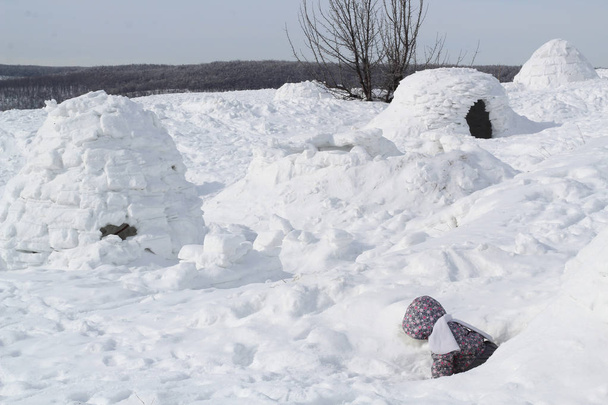 El niño sale de la cueva de nieve - habitando Inuit, Igloo
. - Foto, imagen